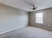 Thumbnail 16 of 26 - an empty living room with a ceiling fan and a window