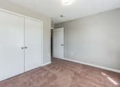 Thumbnail 13 of 26 - an empty bedroom with white closets and carpeting