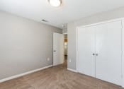 Thumbnail 14 of 26 - a bedroom with white closets and a door to a hallway