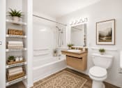 Thumbnail 24 of 24 - A bathroom with a white toilet, a sink, and a shower.