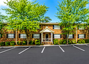 Thumbnail 7 of 13 - Brick apartment buildings with parking area at Stratford Arms Apartments, Riverdale, GA 30274