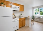 Thumbnail 8 of 8 - A kitchen with white appliances and wooden cabinets.