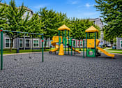Thumbnail 4 of 17 - A playground with a yellow and green slide and a green and yellow swing set.
