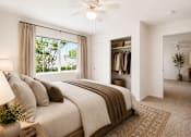 Thumbnail 22 of 24 - A bedroom with a large bed and a ceiling fan.