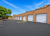 Thumbnail 8 of 24 - A parking lot with a building in the background.