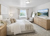 Thumbnail 11 of 12 - A bedroom with a large bed, a dresser, and a painting on the wall.