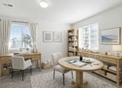 Thumbnail 8 of 9 - A well-lit room with a desk, chair, and a round table with a blue cushion. at Diamond Fork Apartments, Spanish Fork, UT, 84660