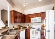 Thumbnail 7 of 7 - A kitchen with white appliances and wooden cabinets.
