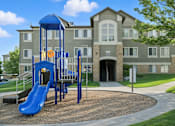 Thumbnail 3 of 9 - A playground with a blue slide in front of a building. at Diamond Fork Apartments, Spanish Fork, 84660