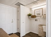 Thumbnail 23 of 24 - A laundry room with a sign on the wall and a basket of plants on the shelf.