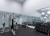 Thumbnail 6 of 17 - A gym with a variety of equipment including a squat rack, bench press, and dumbbells. at Parkland at Orange Park Apartments , Apartments, Orange Park, FL
