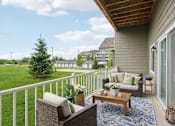 Thumbnail 12 of 13 - Private balcony with seating and green space views at Lake Ridge Apartments, Prior Lake