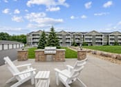 Thumbnail 2 of 13 - Outdoor patio with grilling station and seating at Lake Ridge Apartments, Prior Lake, MN 55379