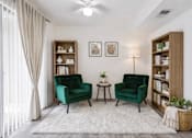 Thumbnail 7 of 8 - A living room with two green chairs and a white rug.