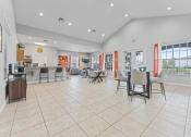 Thumbnail 17 of 23 - a dining area with tables and chairs and a kitchen with a counter and windows