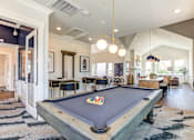 Thumbnail 19 of 25 - A pool table is in the middle of a room with a striped rug.