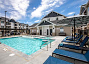 Thumbnail 12 of 25 - A swimming pool surrounded by lounge chairs and umbrellas.