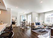 Thumbnail 1 of 25 - A modern living room with a grey couch and a coffee table.