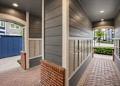 Thumbnail 7 of 17 - A long hallway with brick floors and a brick pillar.