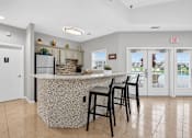 Thumbnail 11 of 37 - A kitchen with a bar and chairs.
