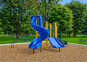 Thumbnail 8 of 21 - Playground with spiral slide and wood chips at Northview Park Apartments, Sterling Heights