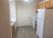 Thumbnail 6 of 16 - an empty kitchen with white appliances and wood floors