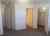 Thumbnail 7 of 16 - a bedroom with two doors and a closet and a door to a hallway