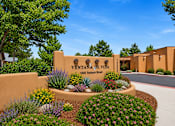 Thumbnail 1 of 24 - The image shows a beautifully landscaped entrance to Ventana de Vida with a clear blue sky above.