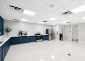 Thumbnail 8 of 17 - A clean, empty office space with blue accent walls and white floors.