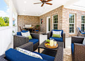 Thumbnail 1 of 12 - A patio with a table and chairs and a tray of fruit on it.