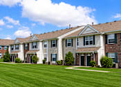 Thumbnail 3 of 16 - A row of houses with green lawns in front.