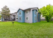 Thumbnail 13 of 13 - a blue and gray apartment building on a grassy lawn