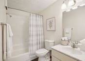Thumbnail 19 of 19 - A white bathroom with a toilet, sink, and shower.