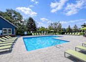Thumbnail 2 of 19 - A pool surrounded by sun loungers and trees.