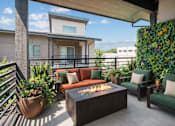 Thumbnail 11 of 21 - Rooftop patio with fire table and seating at Harper Ridge Apartments, Idaho
