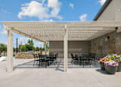 Thumbnail 4 of 21 - Outdoor patio with pergola and dining tables at Harper Ridge Apartments, Idaho, 83642