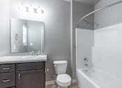Thumbnail 18 of 29 - A white bathroom with a toilet, sink, and bathtub.