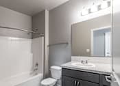 Thumbnail 17 of 29 - A bathroom with a white tub, sink, and toilet.