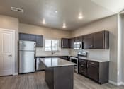 Thumbnail 1 of 29 - A kitchen with dark wood cabinets and stainless steel appliances.