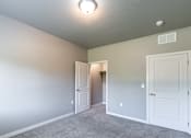 Thumbnail 15 of 29 - A room with a carpeted floor and two white doors.