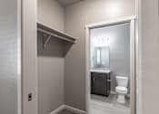 Thumbnail 19 of 29 - A bathroom with a toilet, sink, and a mirror.