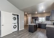 Thumbnail 9 of 29 - A modern laundry room with a washer and dryer built into the cabinetry.