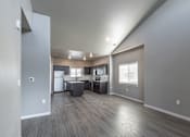 Thumbnail 5 of 29 - A spacious kitchen and living room with wood flooring and white appliances.
