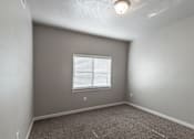 Thumbnail 11 of 29 - A room with a window and carpeted floor.