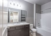 Thumbnail 16 of 29 - A bathroom with a toilet, sink, and bathtub.