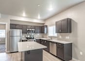 Thumbnail 4 of 29 - A modern kitchen with stainless steel appliances and dark wood cabinets.