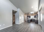 Thumbnail 8 of 29 - A spacious living area with a kitchen in the background.