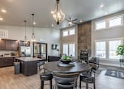 Thumbnail 28 of 29 - A modern kitchen with a dining table and chairs.