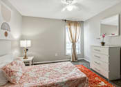 Thumbnail 14 of 28 - A bedroom with a bed, dresser, and window.