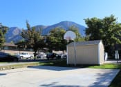 Thumbnail 8 of 13 - a basketball hoop in front of a building with mountains in the background
